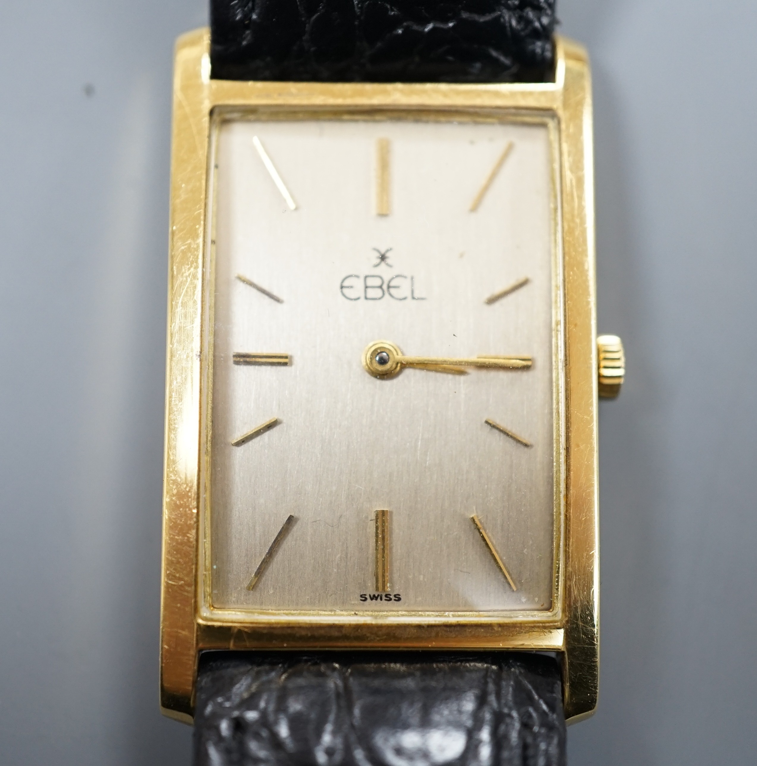 A gentleman's 750 yellow metal Ebel rectangular dial manual wind wrist watch, on associated leather strap, case diameter 22mm, gross weight 24.3 grams.